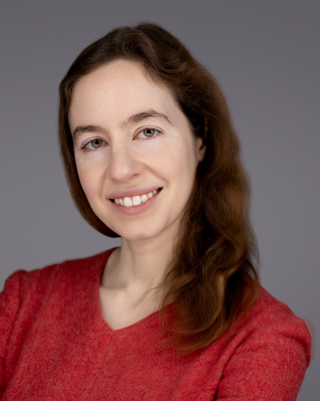 Portrait of Dr Maria Valkovskaya smiling against a grey background.